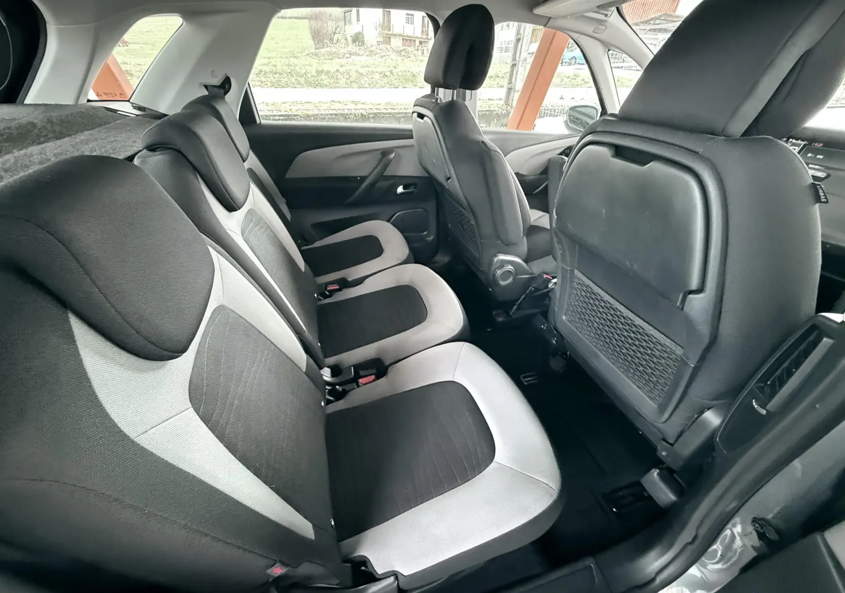 Vue intérieure côté droit montrant les sièges arrière en tissu bicolore noir et gris du Citroën C4 Picasso 2015.