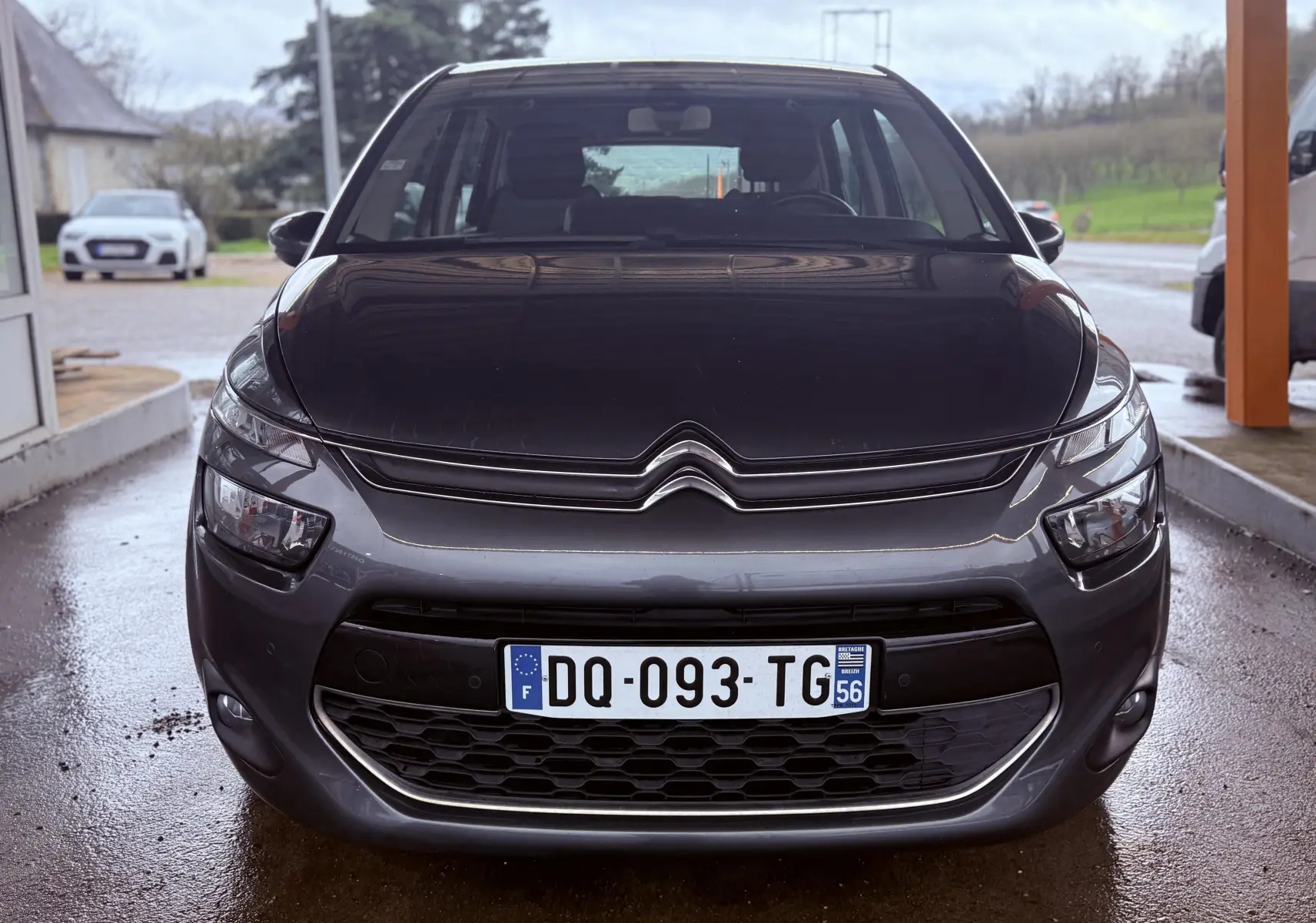 Vue frontale d'une Citroën C4 Picasso gris platinium métal avec calandre distinctive et plaque d'immatriculation française.