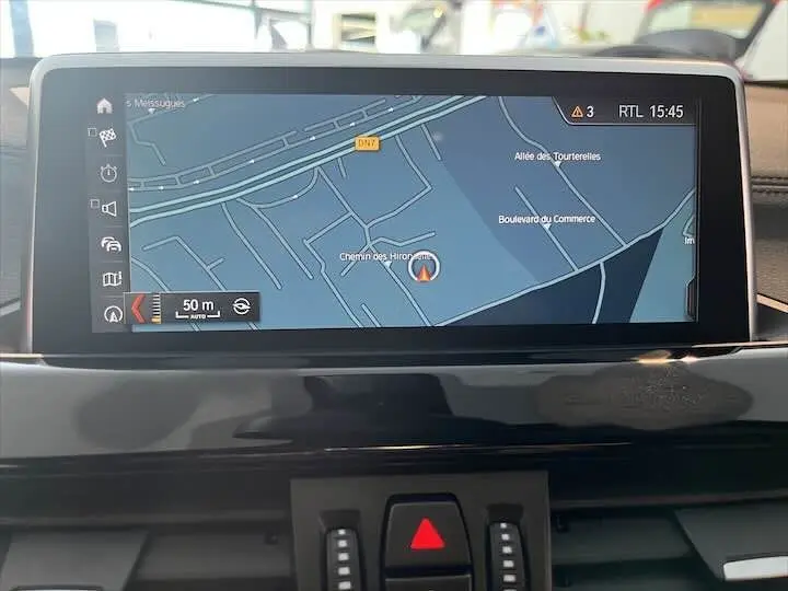 Écran de navigation GPS intérieur du BMW X2 noir métal, affichant une carte routière détaillée en mode jour.
