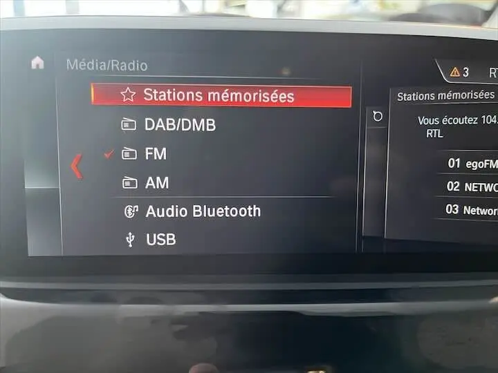 Écran multimédia du BMW X2 sDrive 18i 2022 affichant les stations radio mémorisées en mode FM.