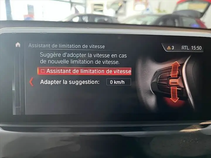 Écran intérieur du BMW X2 affichant l'assistant de limitation de vitesse avec commandes au volant visibles.
