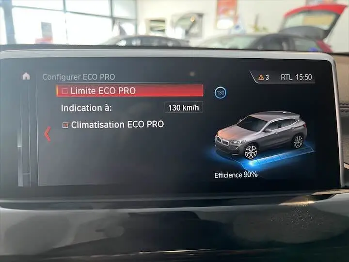 Écran de bord BMW X2 affichant le mode ECO PRO avec une illustration du SUV gris métallisé en vue 3/4 avant.