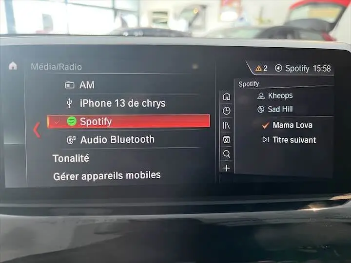 Écran multimédia du BMW X2 noir métal 2022 affichant la sélection Spotify avec liste de lecture active.