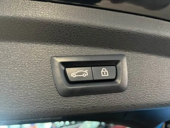 Boutons de fermeture de coffre et verrouillage intégrés dans le panneau intérieur noir d’un BMW X2 sDrive 18i 2022.