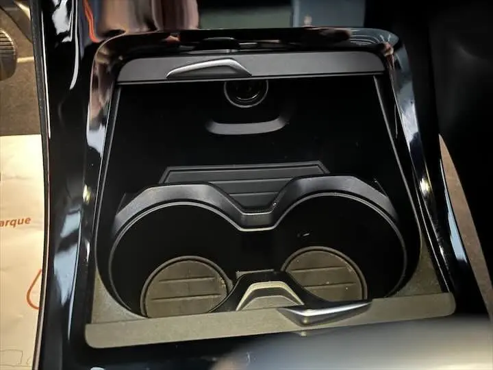 Gros plan sur le porte-gobelets noir brillant du BMW X2 sDrive 18i, mettant en valeur la console centrale moderne.