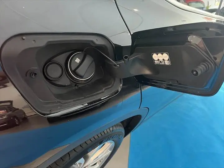 Gros plan sur la trappe à carburant noire métal du BMW X2 sDrive 18i, vue côté gauche arrière avec roue visible.