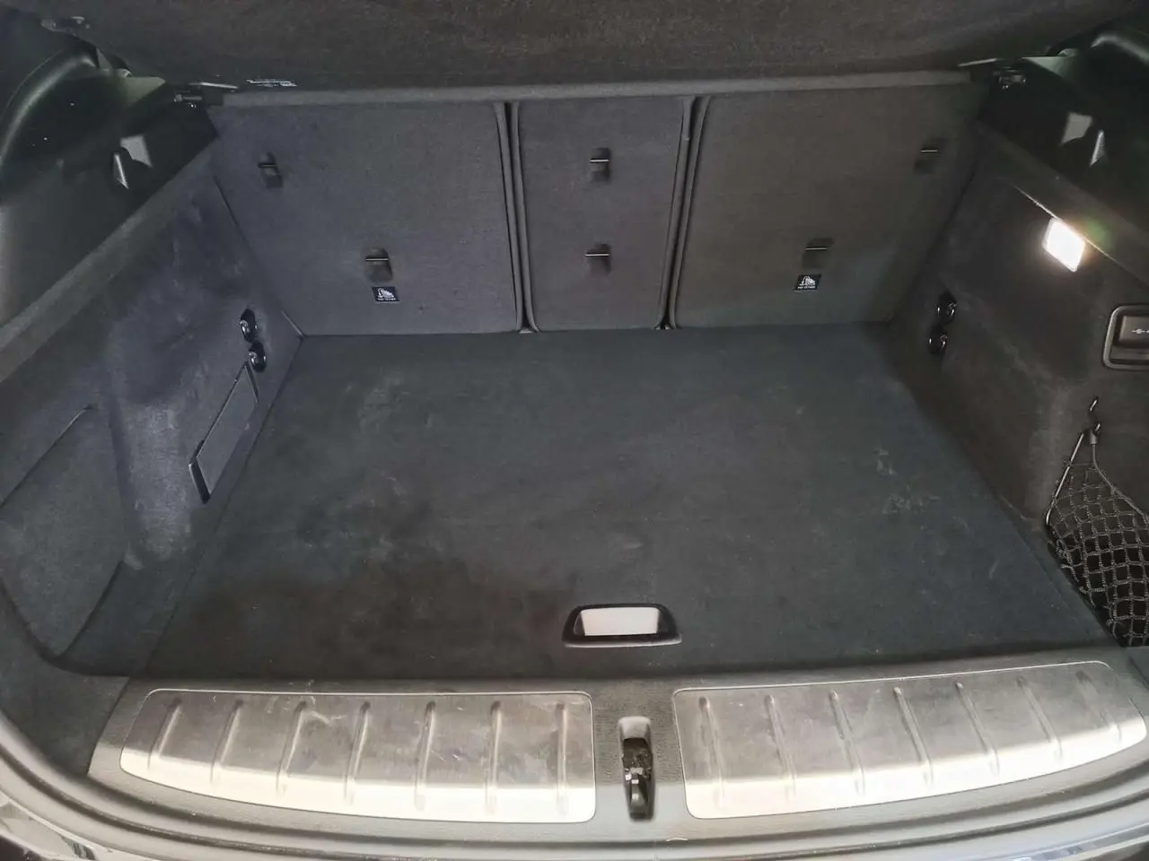 Coffre spacieux en tissu noir du BMW X2 sDrive 18i 2022, vue intérieure depuis l'arrière avec seuil métallique.