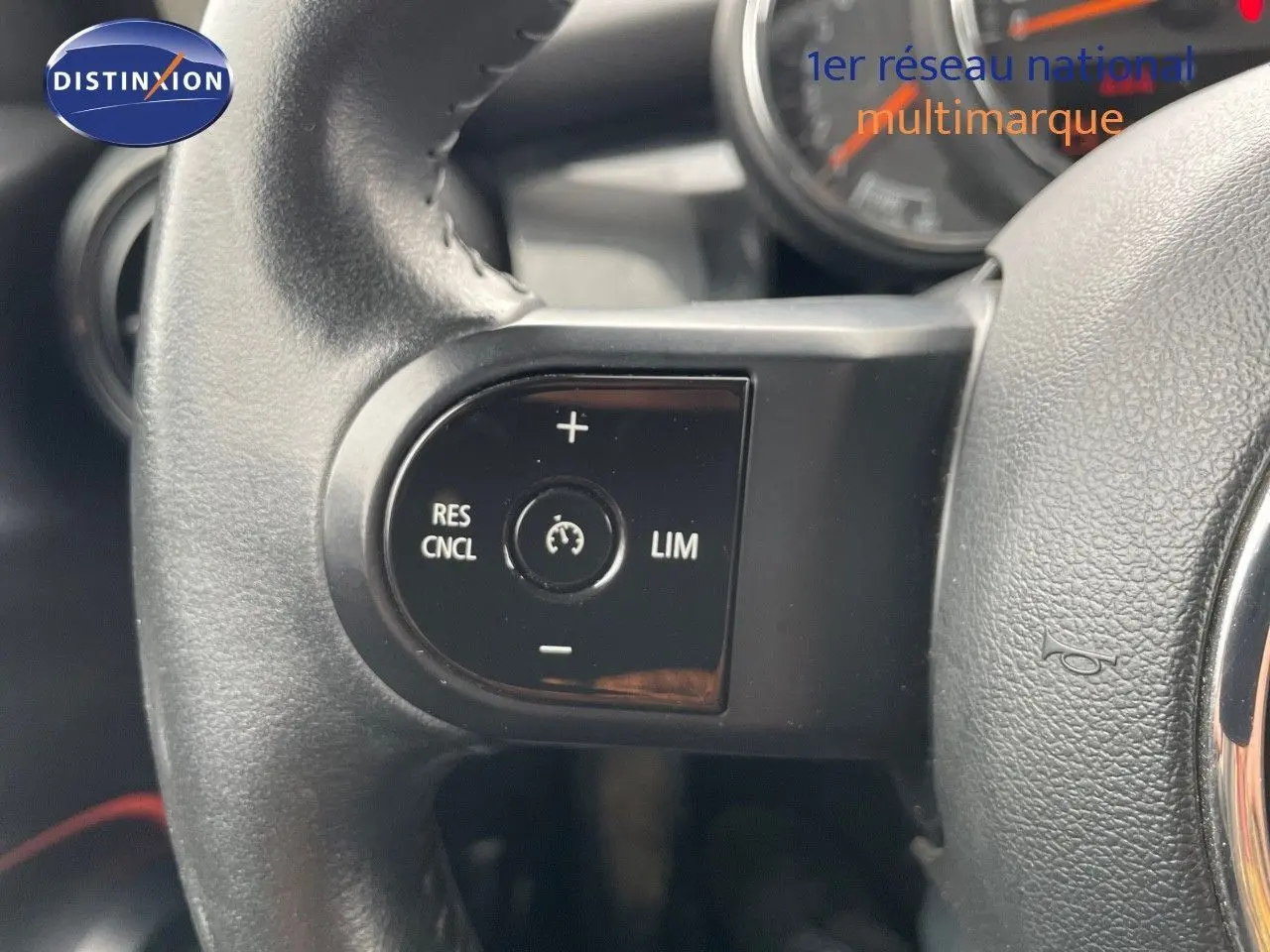 Gros plan sur les commandes de régulateur de vitesse au volant en cuir noir d'une MINI 2023 couleur Melting Silver Metal.