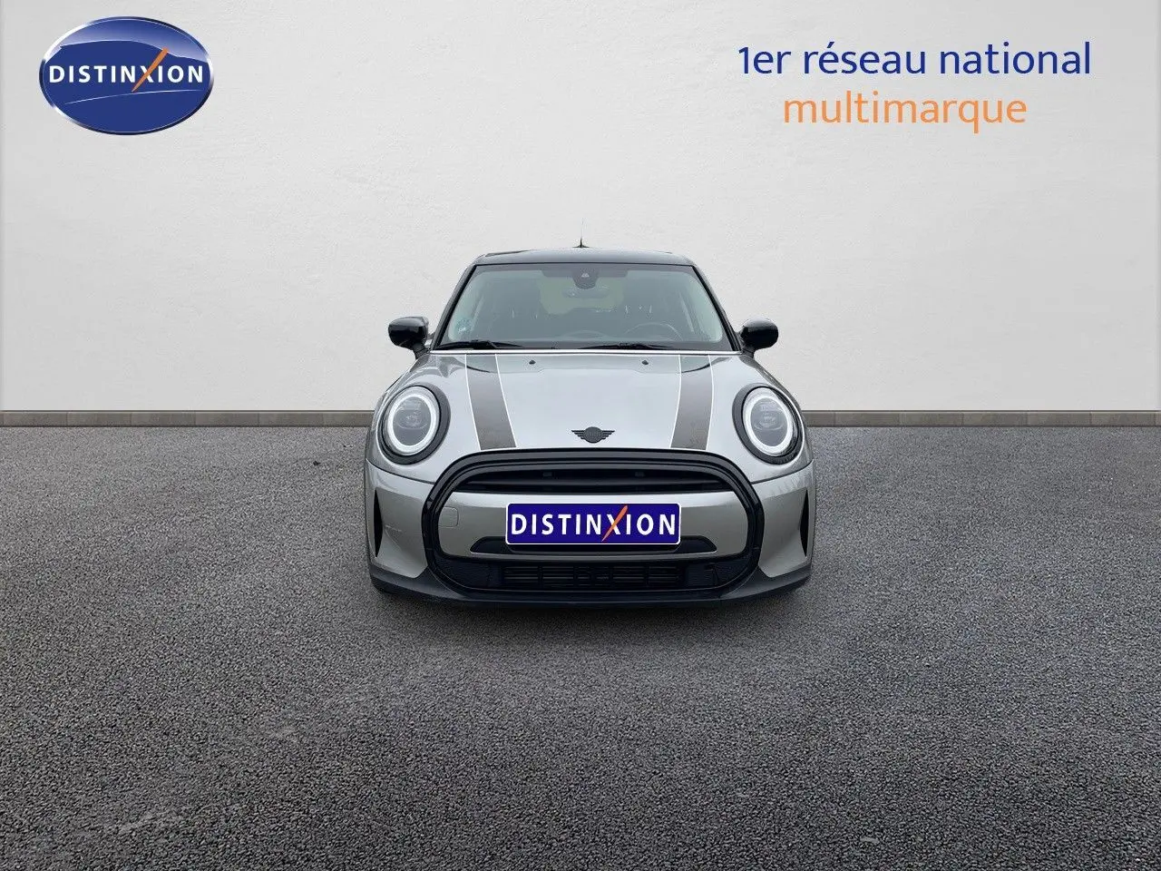 Vue frontale d'une MINI 1.5 136CH STEPTRONIC 2023 en Melting Silver Metal avec bandes noires sur le capot.