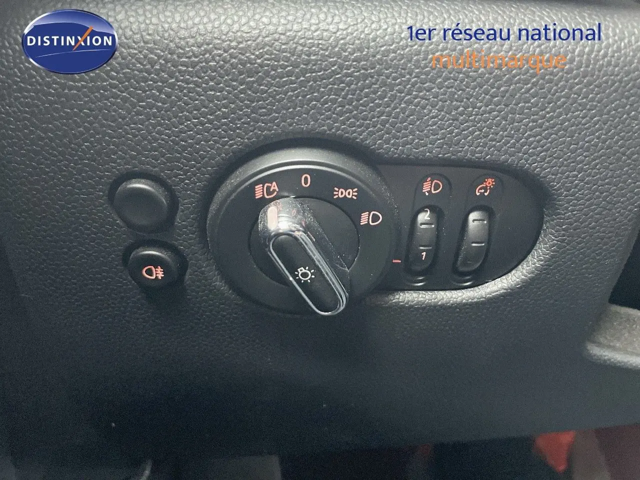 Commande des phares et réglages d'éclairage sur tableau de bord noir d'une MINI 1.5 136CH STEPTRONIC 2023.