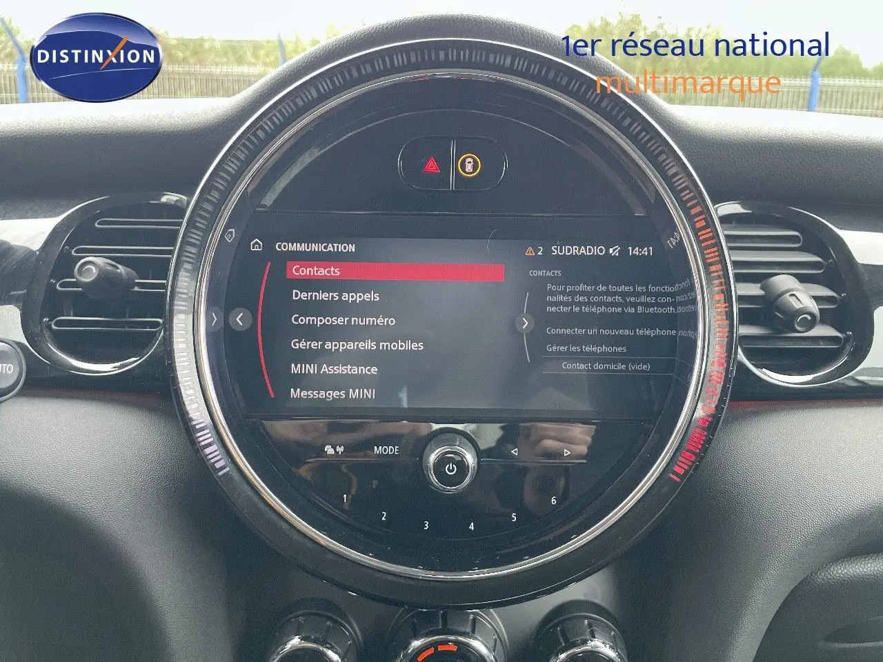 Tableau de bord de MINI 2023 avec écran central rond affichant menu communication, entouré d'aérations noires.