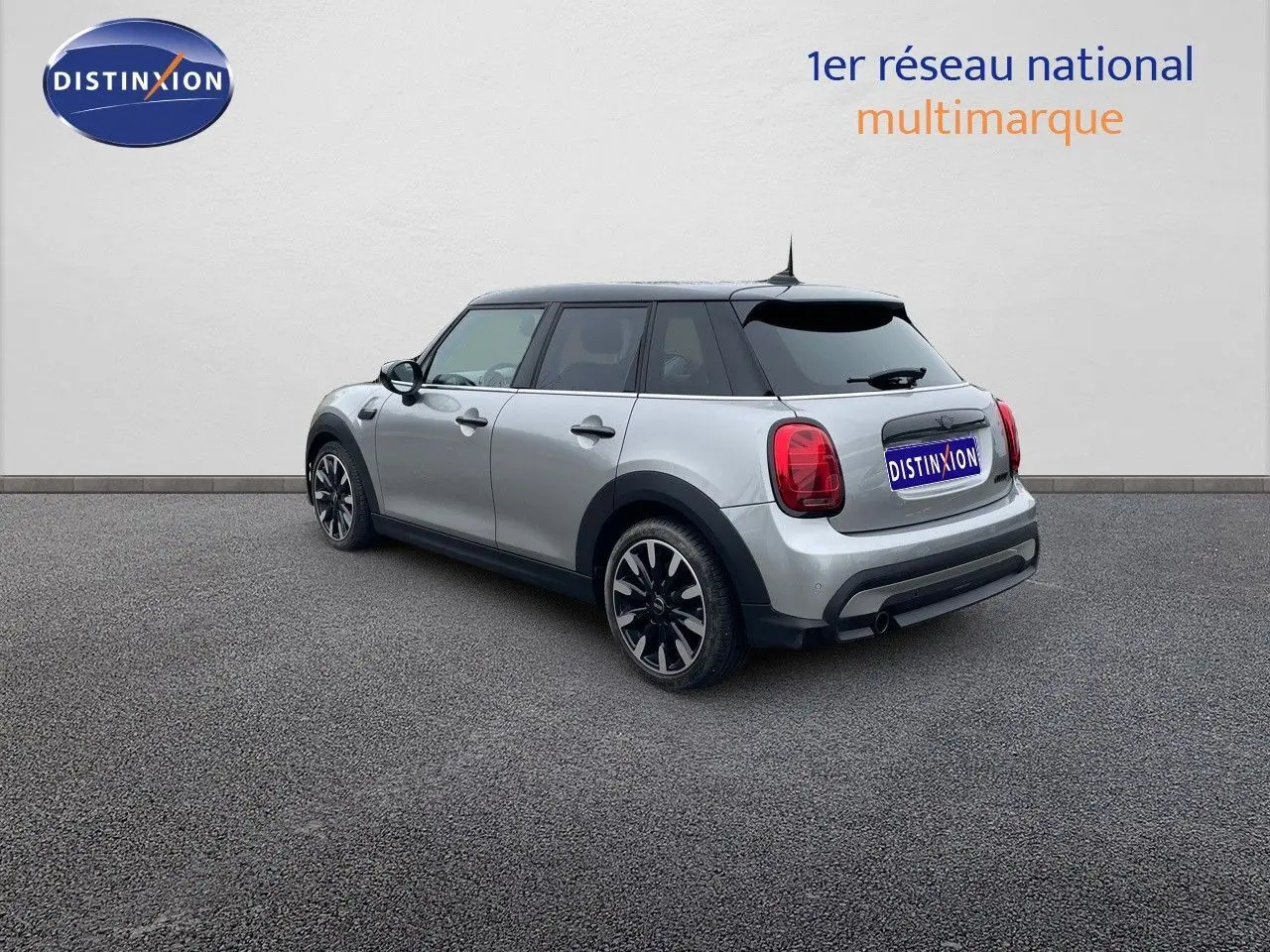 Vue 3/4 arrière droite d'une MINI 1.5 136CH STEPTRONIC 2023 en Melting Silver Metal avec toit noir et jantes bi-ton.