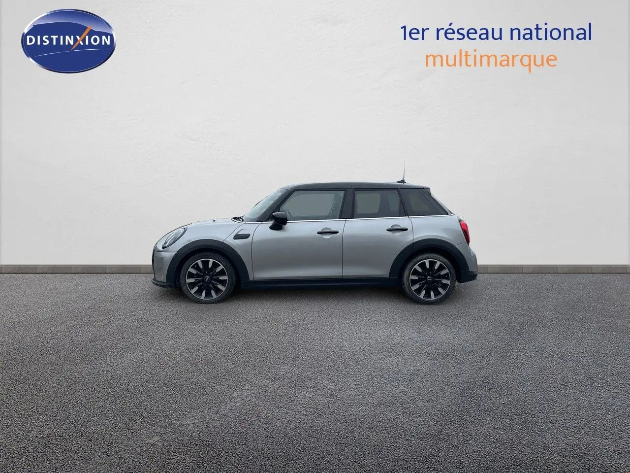 Profil droit d'une MINI 1.5 136CH STEPTRONIC 2023 en Melting Silver Metal avec toit noir et jantes bi-ton.