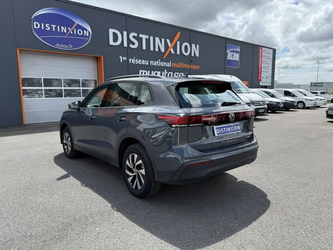 Volkswagen Tiguan 1.5 eHybrid gris dauphin vu 3/4 arrière droit avec badge eHybrid sur hayon.