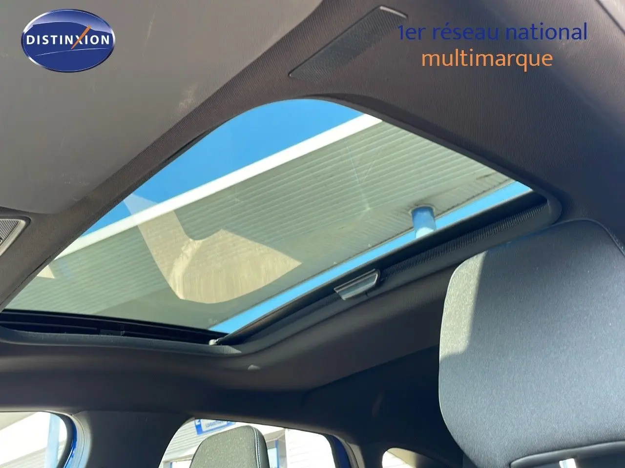 Toit ouvrant panoramique ouvert sur l'intérieur noir du Renault Captur E-Tech Hybrid 2025, vue partielle côté conducteur.