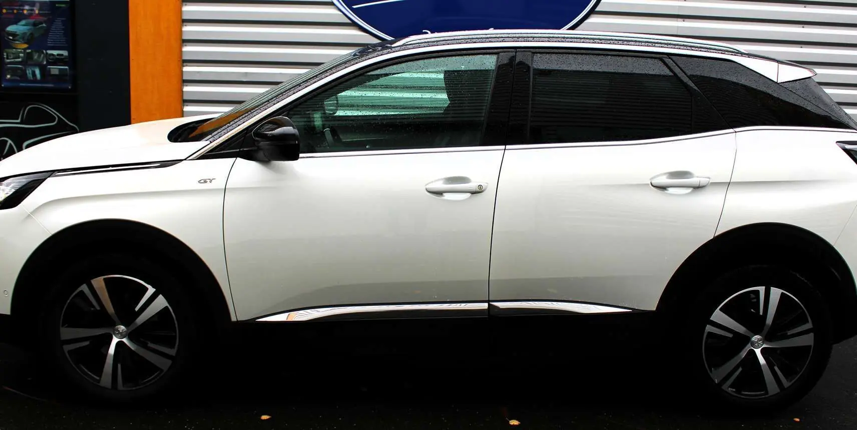 Profil côté gauche d'un Peugeot 3008 blanc nacré 2025 GT avec toit panoramique ouvrant et jantes bi-ton.