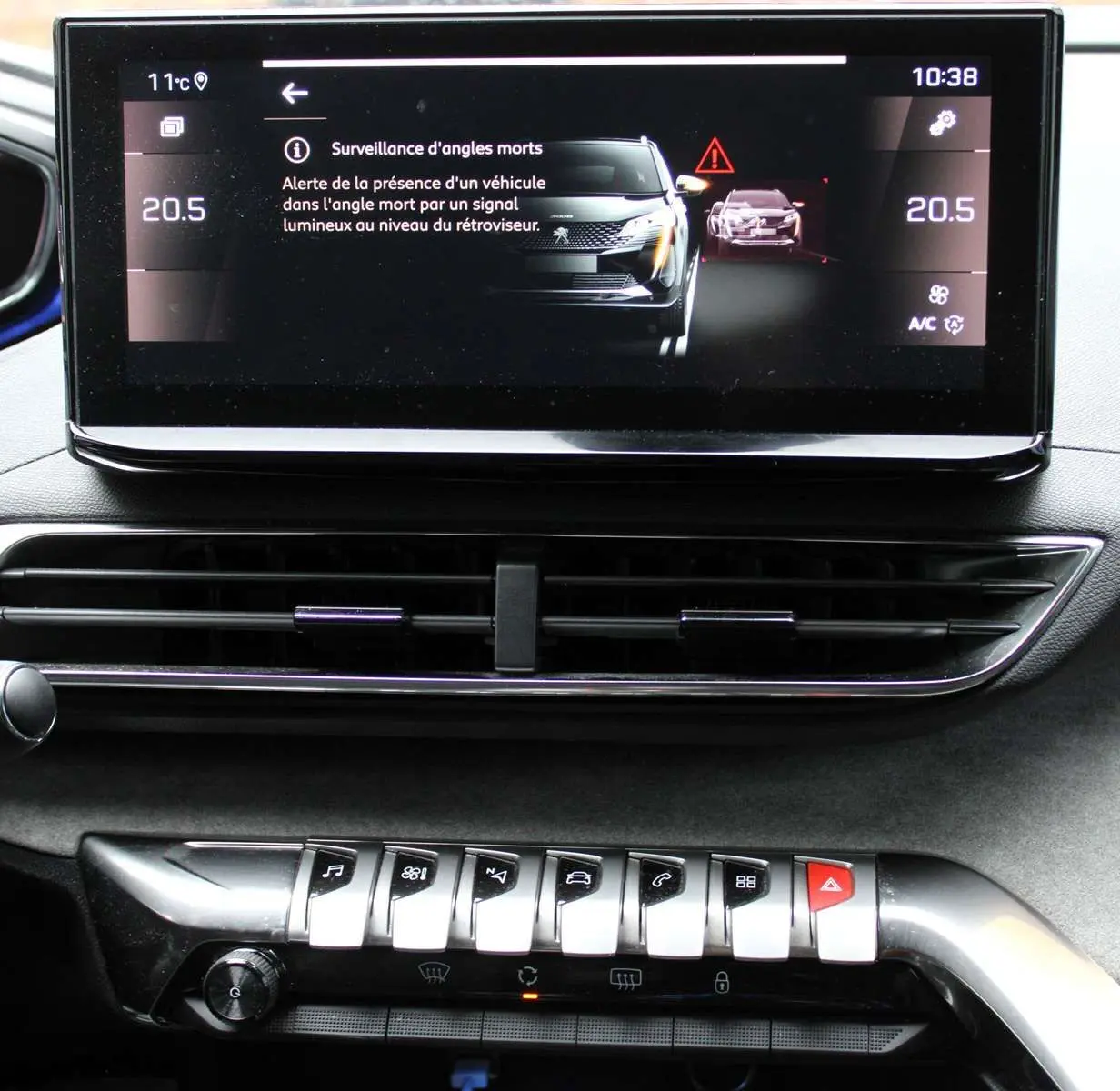 Écran central du Peugeot 3008 2025 montrant l'alerte de surveillance d'angles morts dans un intérieur noir.