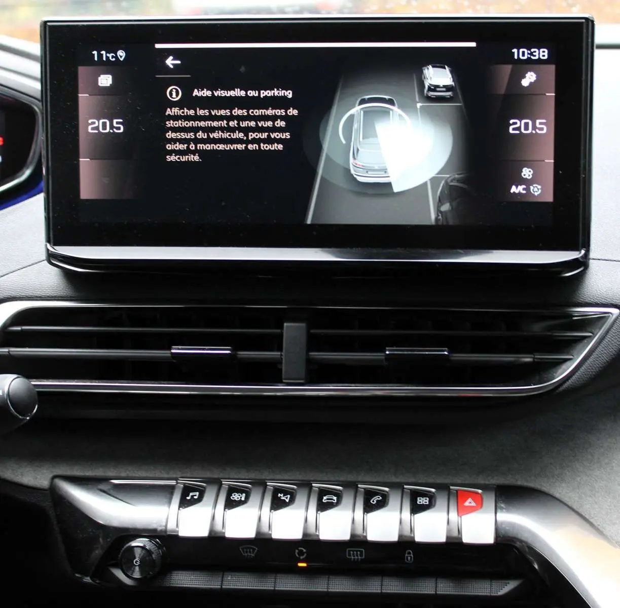 Écran tactile intérieur du Peugeot 3008 2025 affichant l'aide visuelle au parking avec commandes sous la console.