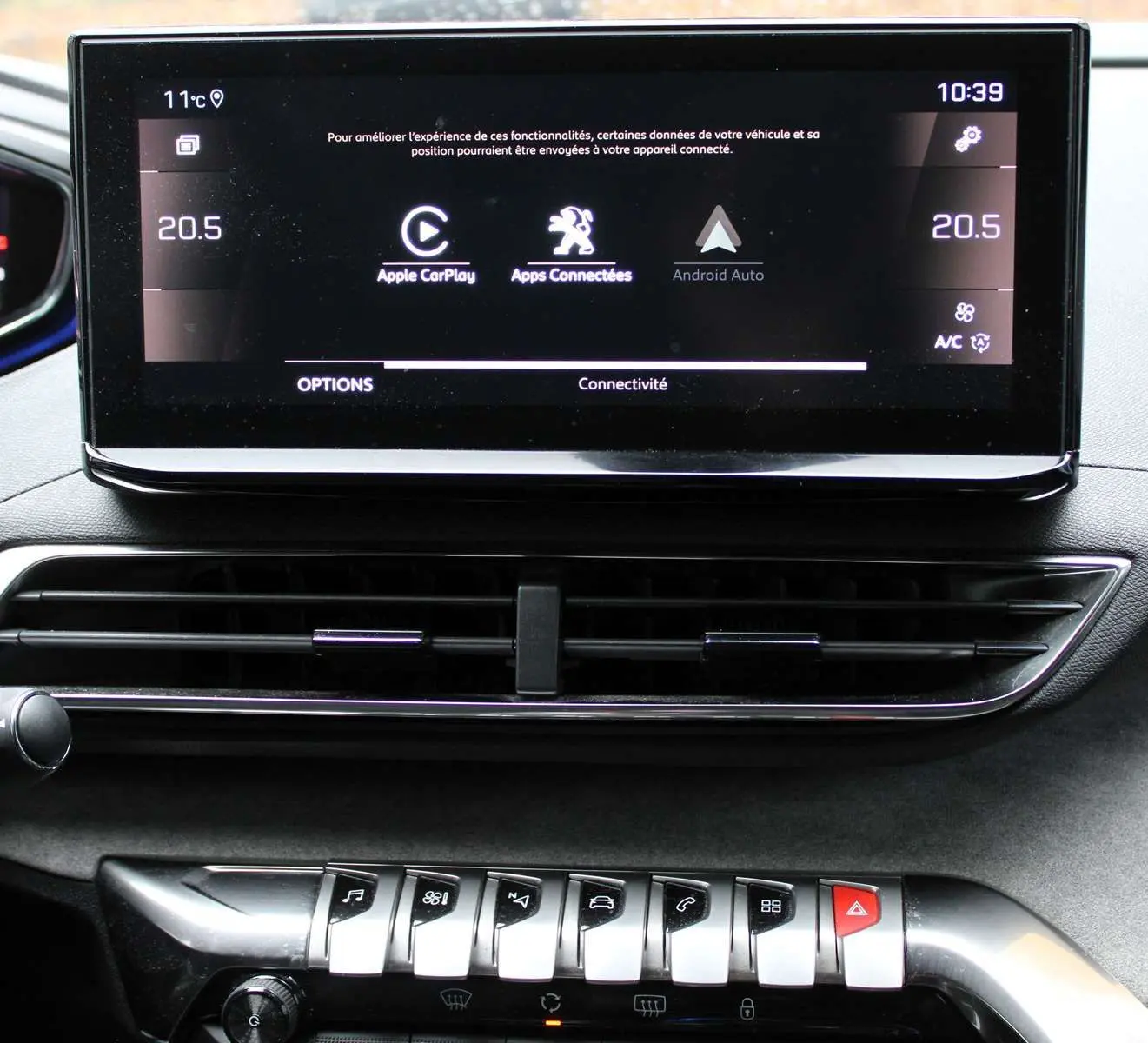 Écran tactile central affichant connectivité Apple CarPlay et Android Auto sur Peugeot 3008 blanc nacré 2025, vue intérieure frontale.