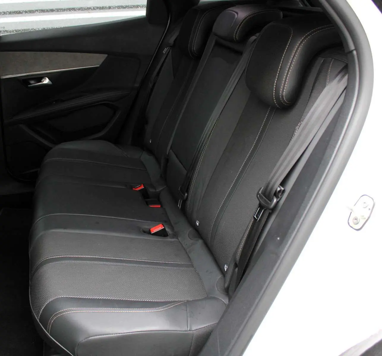 Vue côté gauche des sièges arrière noirs avec surpiqûres contrastantes du Peugeot 3008 blanc nacré 2025.