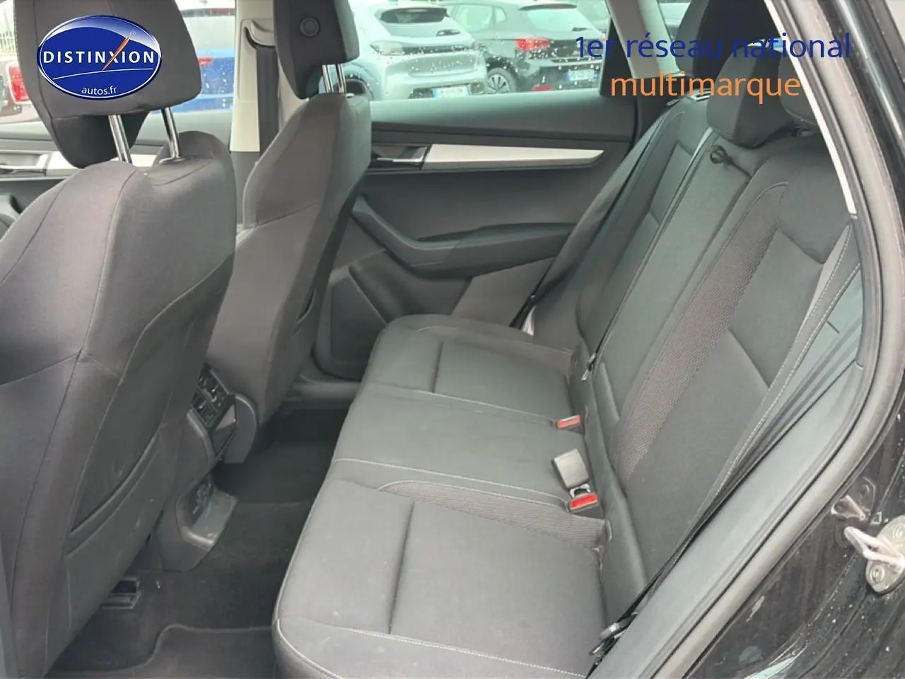 Vue intérieure côté droit des sièges arrière noirs d'un Skoda Karoq 2025 avec porte ouverte et garnitures grises.