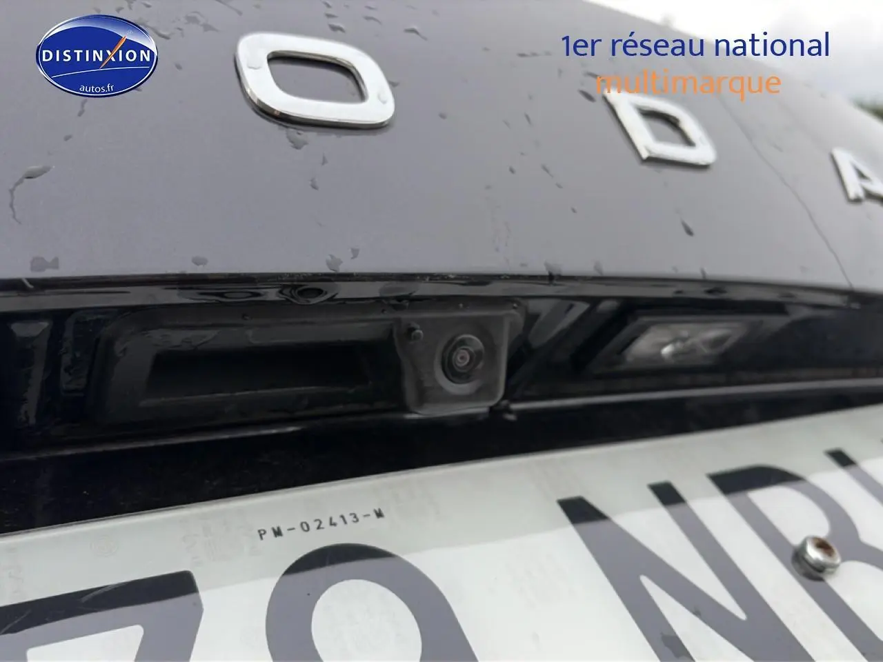 Gros plan sur la caméra de recul noire intégrée au hayon arrière du Skoda Karoq noir 2025.