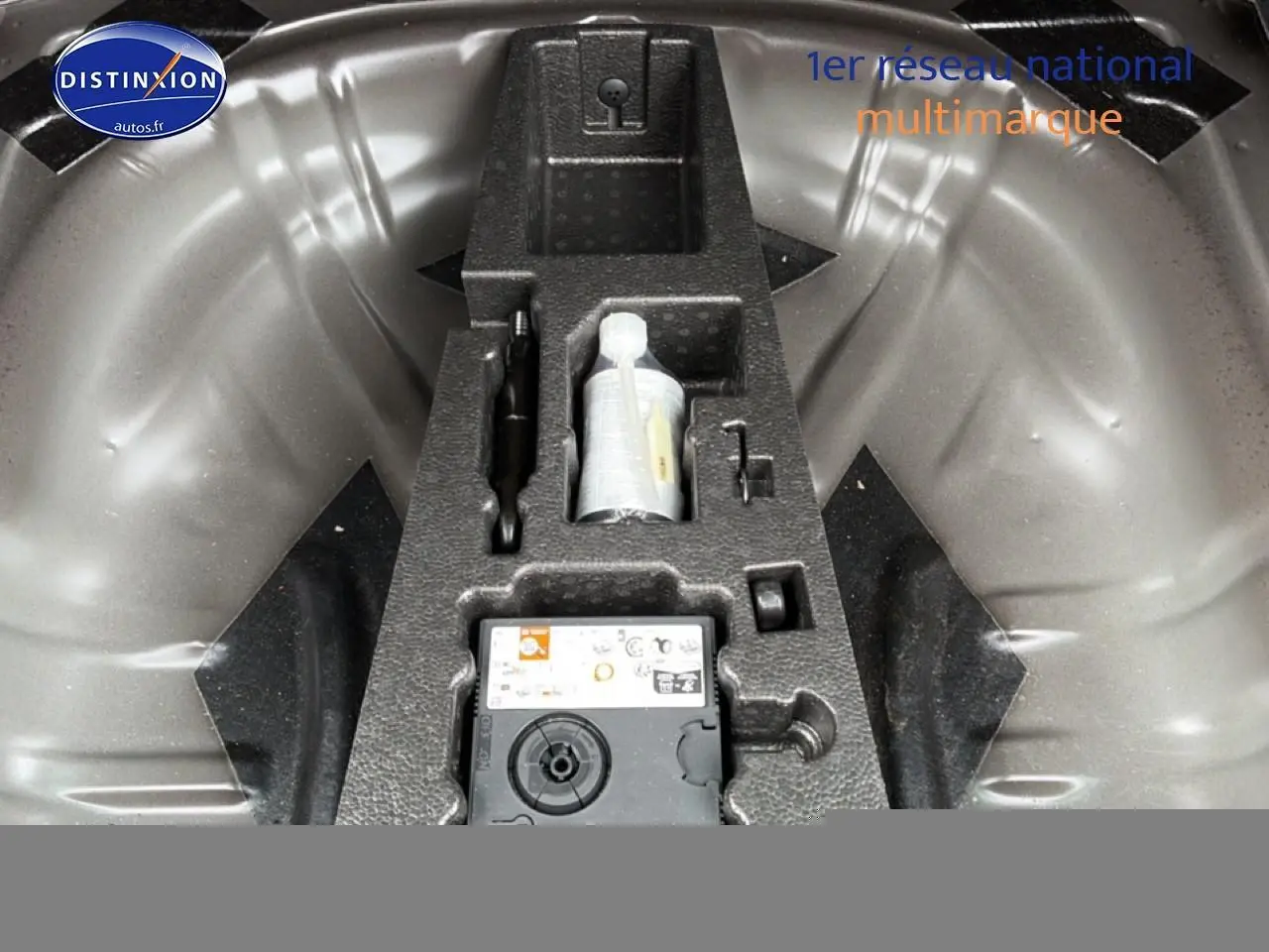 Gros plan sur le rangement sous le coffre du Skoda Karoq noir 2025 avec kit de réparation pneus intégré.