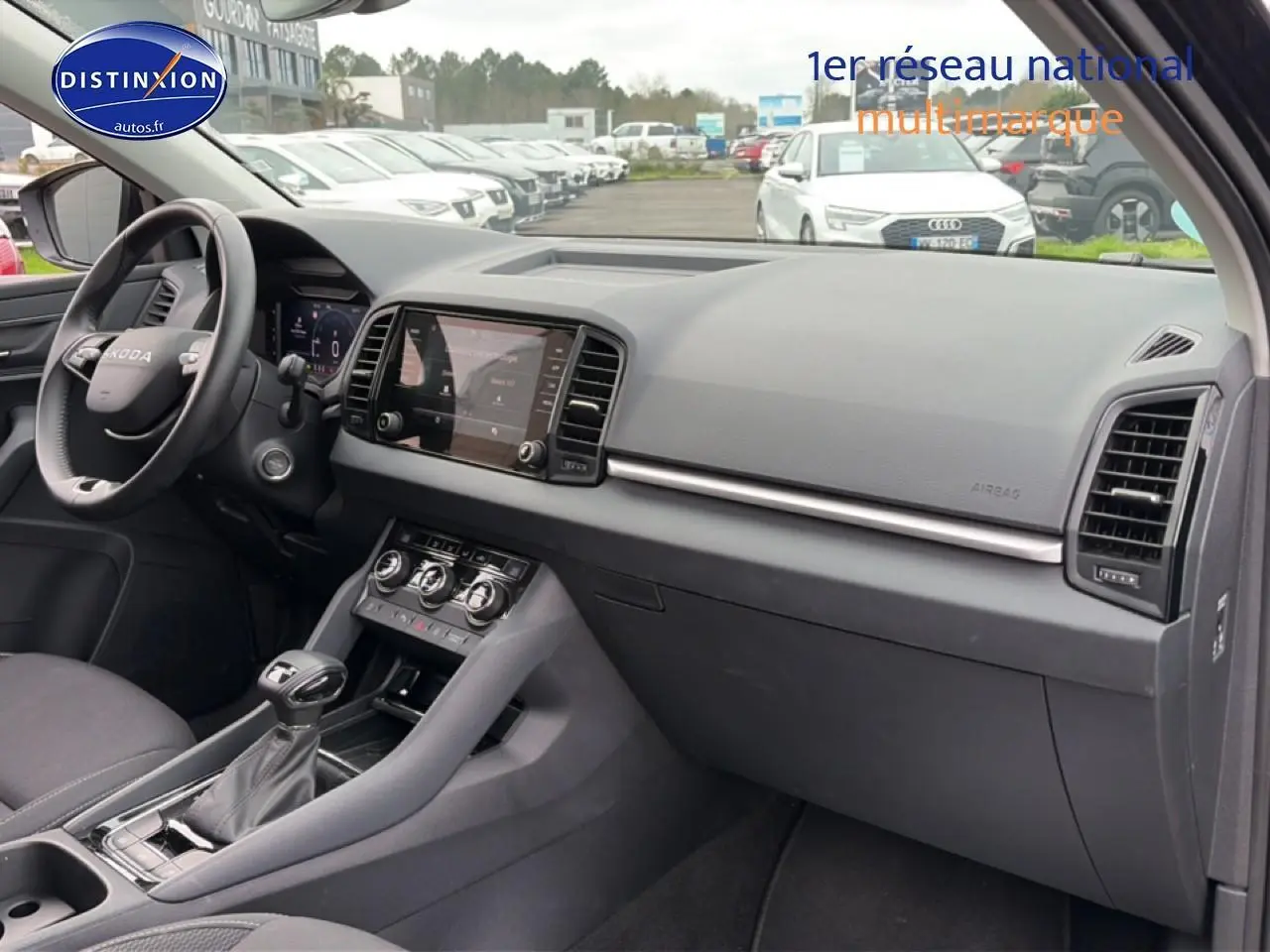 Intérieur noir du Skoda Karoq 2025, vue de profil côté conducteur sur tableau de bord et console centrale.