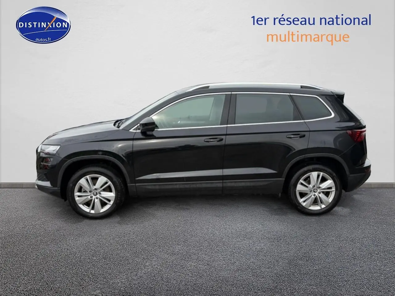 Vue de profil côté gauche d'un Skoda Karoq noir 2025 avec jantes alu et barres de toit visibles.