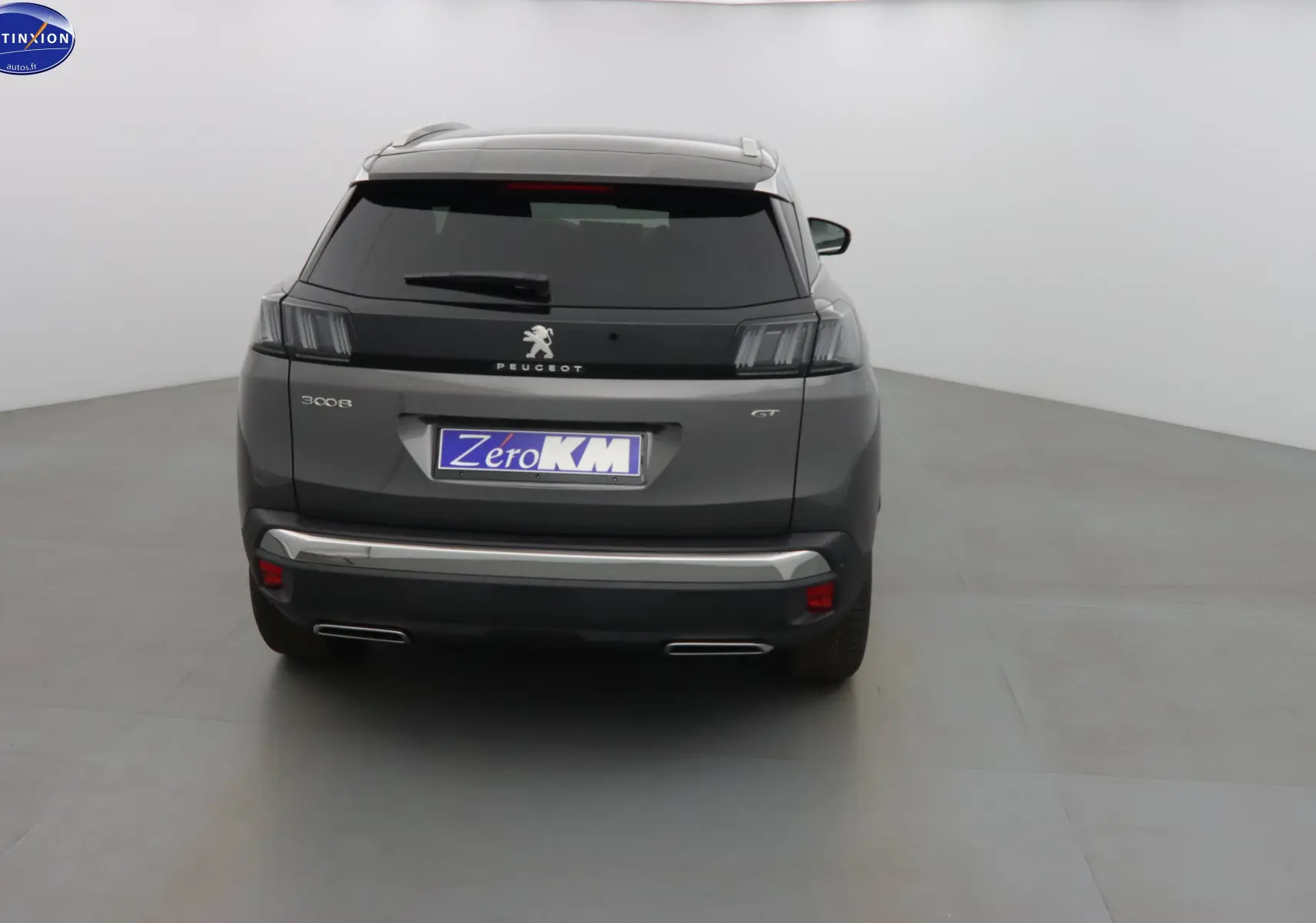 Vue arrière du Peugeot 3008 GT gris platinium métal avec feux teintés et double sortie d'échappement intégrée.
