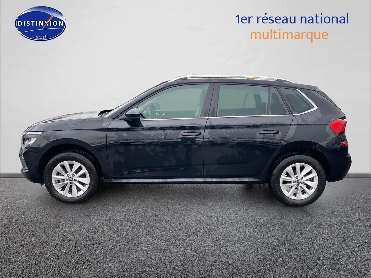 Profil latéral gauche d'un Skoda Kamiq noir 2025 avec jantes alu et barres de toit visibles.