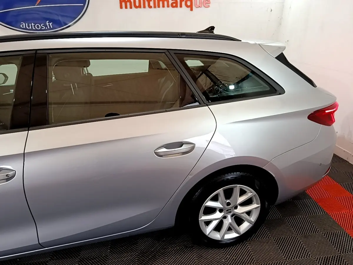 Vue latérale droite d'un break SEAT Leon gris foncé, mettant en valeur la jante alliage et la ligne de toit profilée.