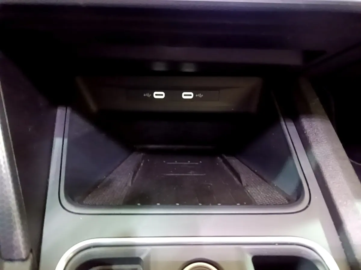 Gros plan sur la zone de recharge par induction et ports USB dans l’habitacle du SEAT Leon gris foncé 2022.