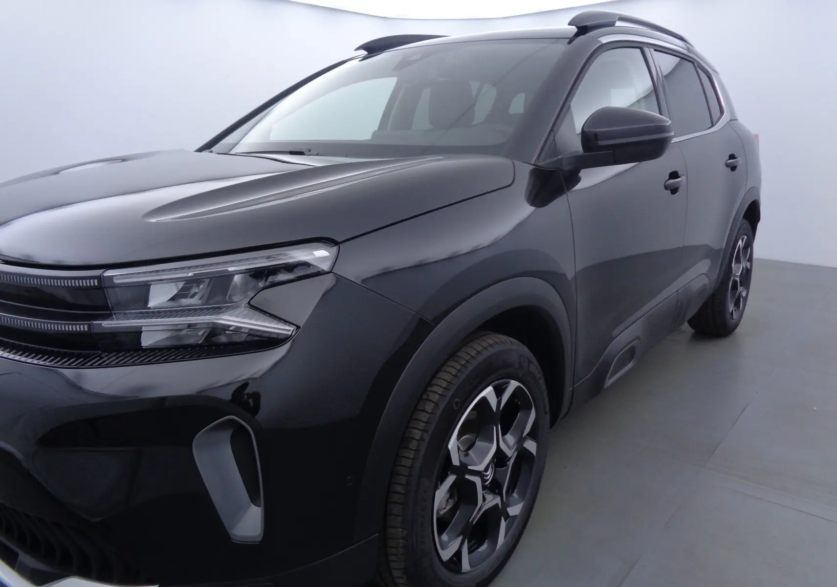 Vue 3/4 avant droit du Citroën C5 Aircross noir métal 2022 avec jantes biton et phares LED distinctifs.