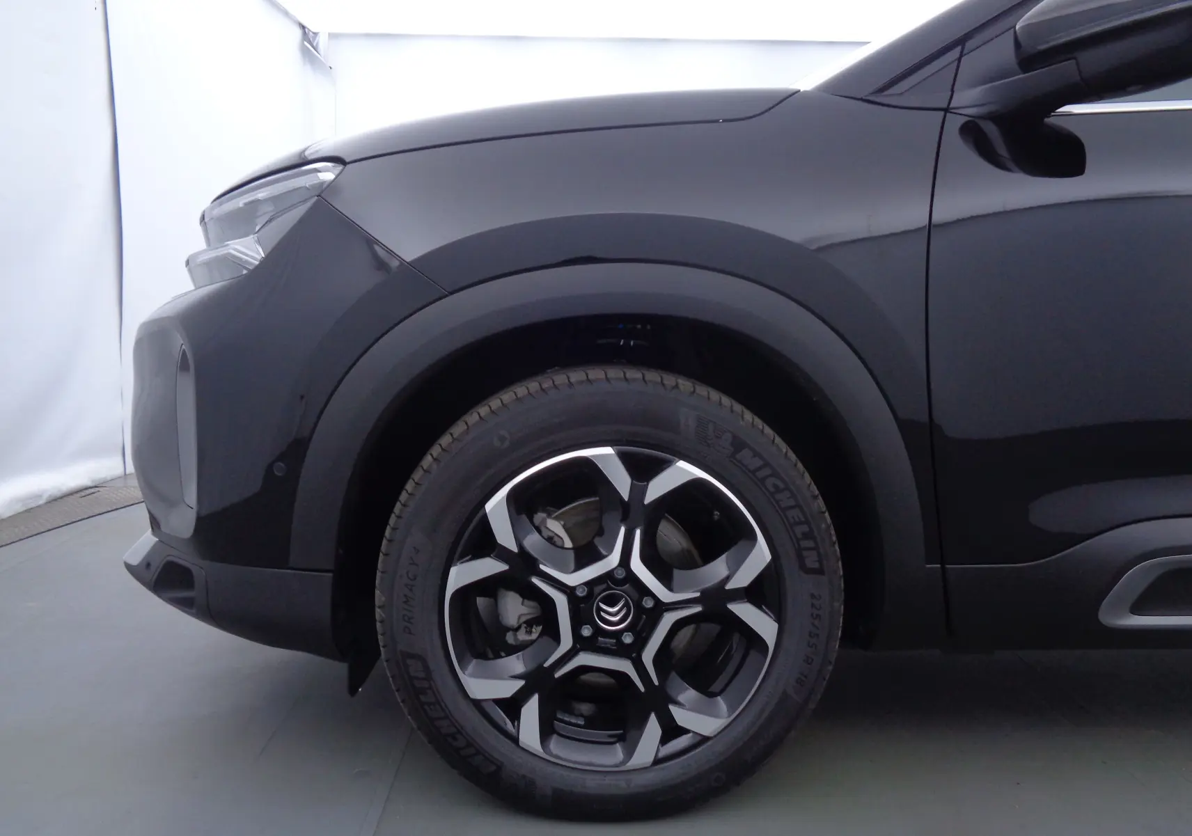 Gros plan sur la roue avant gauche du Citroën C5 Aircross noir métal 2022 avec jante alliage bicolore.