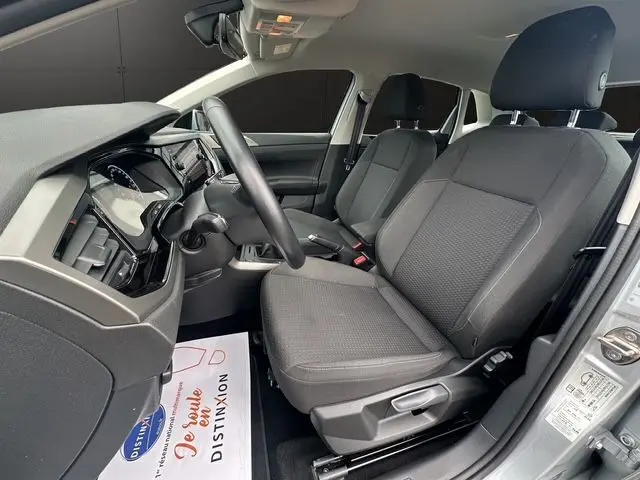 Vue intérieure côté conducteur du Volkswagen Polo VI Lounge Business 2021 avec sièges tissu noir et tableau de bord moderne.