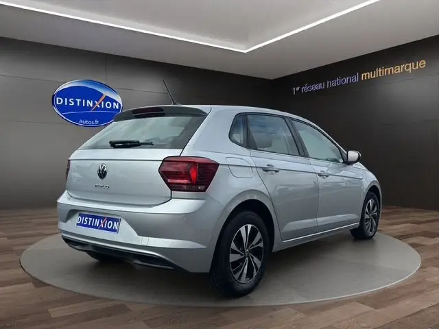 Volkswagen Polo VI Lounge Business gris vue 3/4 arrière droit dans un showroom avec jantes alliage noires.