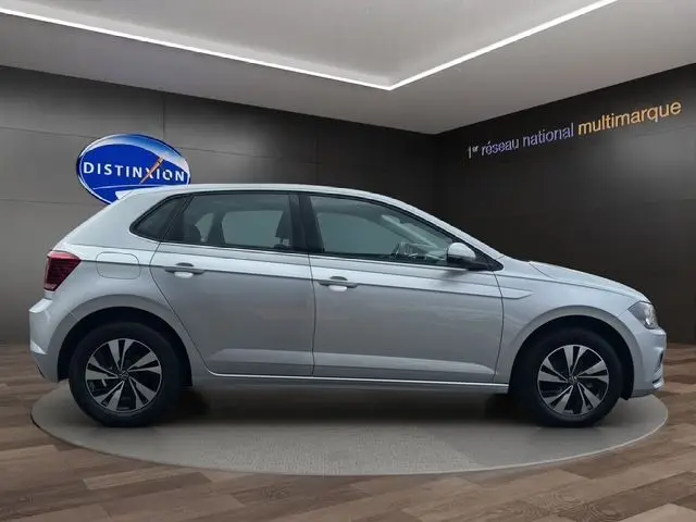 Profil droit d'une Volkswagen Polo VI Lounge Business gris métallisé 2021 avec jantes alliage et vitres teintées en showroom.