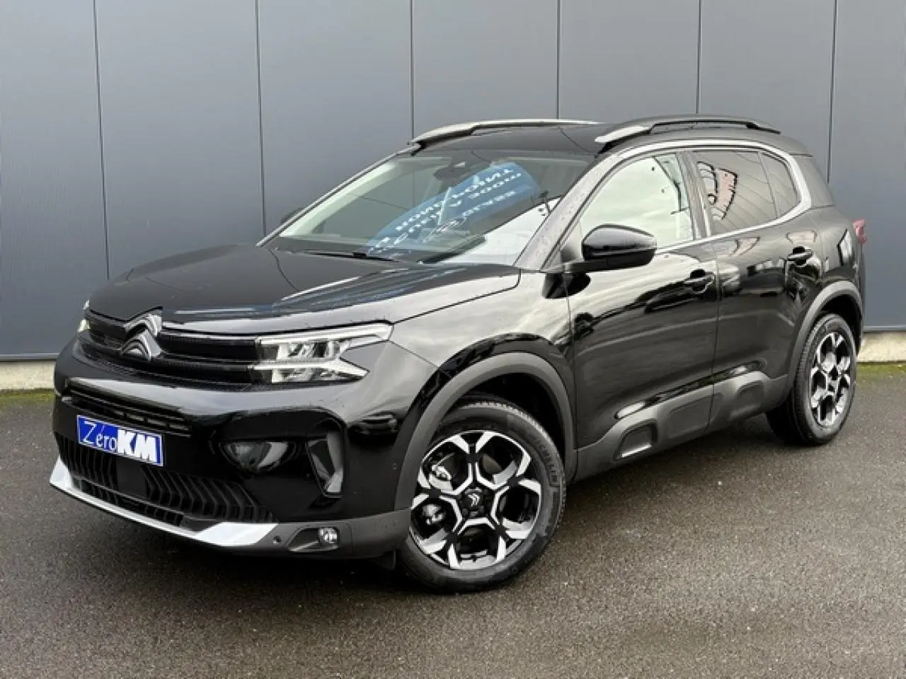 Citroën C5 Aircross Hybrid noir Perla vue 3/4 avant droit avec jantes alliage bi-ton et barres de toit noires.