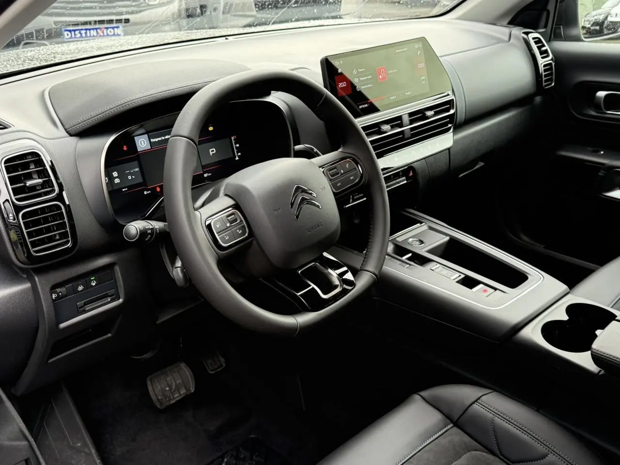 Intérieur noir du Citroën C5 Aircross Hybrid 2025 vu côté conducteur, avec volant cuir et écran tactile 10 pouces.