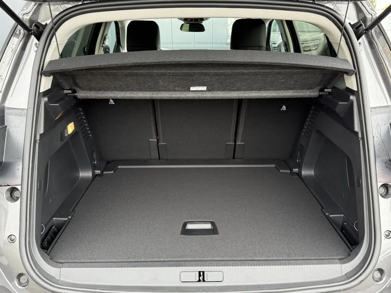 Coffre ouvert vu de l'arrière d'un Citroën C5 Aircross noir Perla, espace de chargement propre et spacieux.