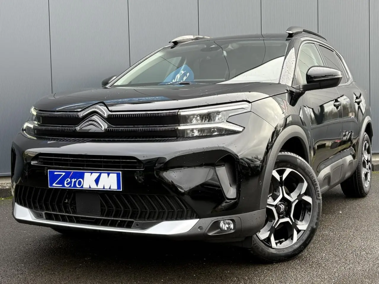 Citroën C5 Aircross Hybrid noir Perla vu 3/4 avant droit avec jantes alliage bi-ton et barres de toit noires.