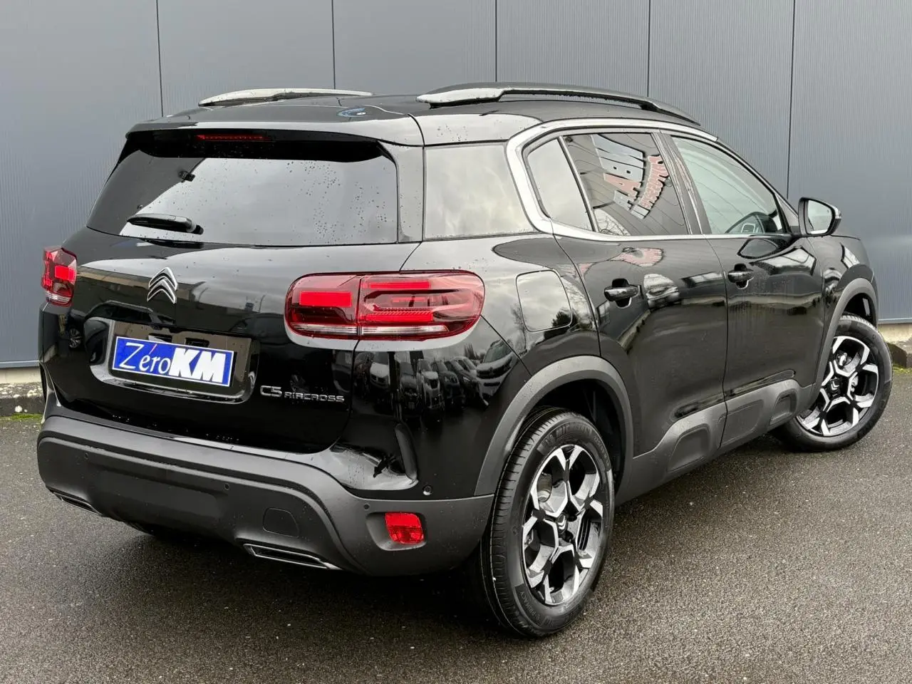 Vue 3/4 arrière droite d'un Citroën C5 Aircross Hybrid noir Perla avec jantes alliage bi-ton et feux LED arrière.
