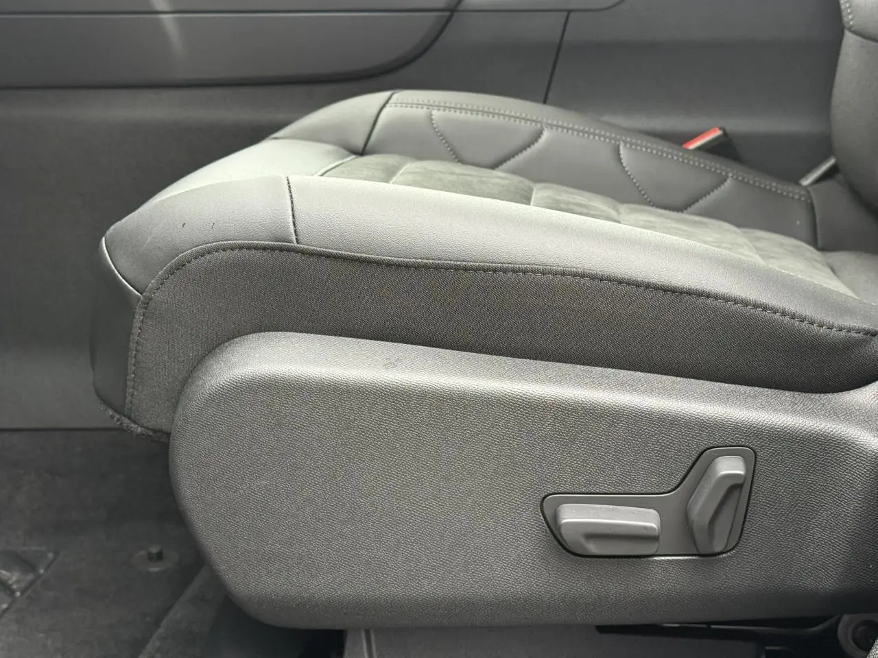 Détail du siège conducteur noir en Alcantara et tissu effet cuir du Citroën C5 Aircross Hybrid 2025, côté gauche avec commandes électriques.