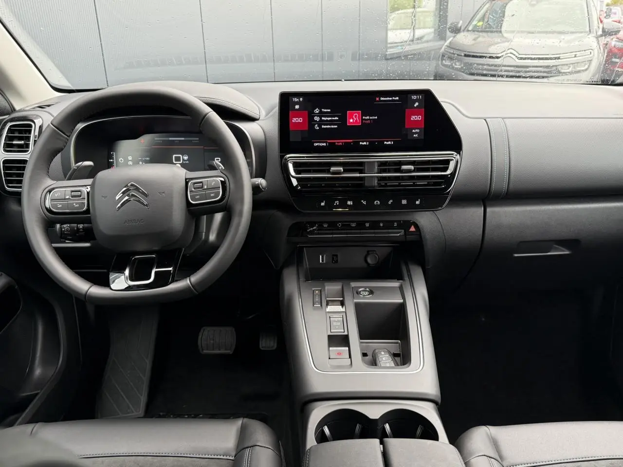 Intérieur noir du Citroën C5 Aircross Hybrid 2025, vue frontale du tableau de bord avec écran tactile 10 pouces et volant multifonction.