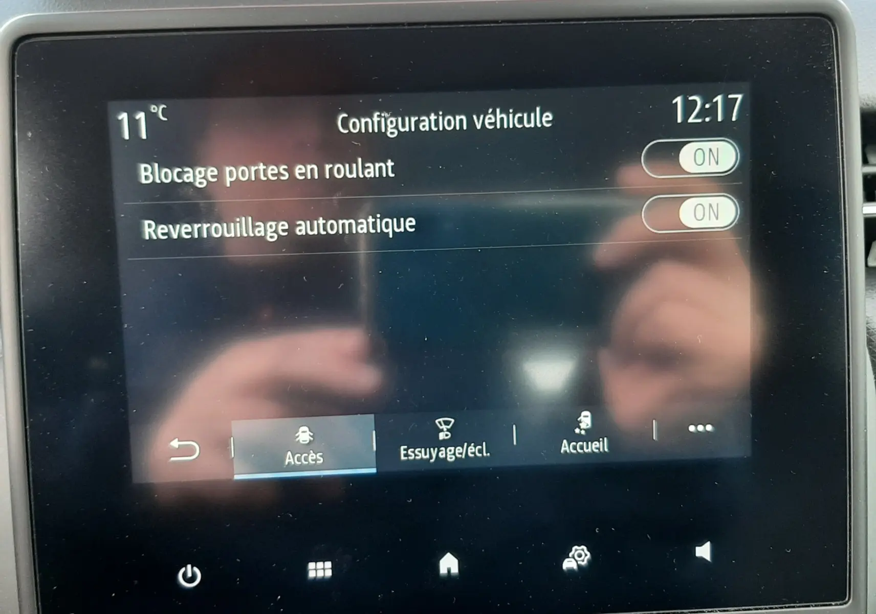 Écran tactile central de la Renault Clio V blanc, affichant la configuration véhicule avec options de verrouillage activées.