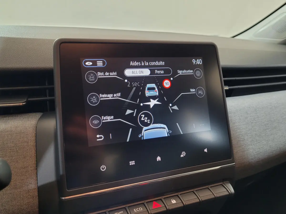Écran tactile central affichant les aides à la conduite dans l’habitacle de la Renault Clio bleu, vue de face.