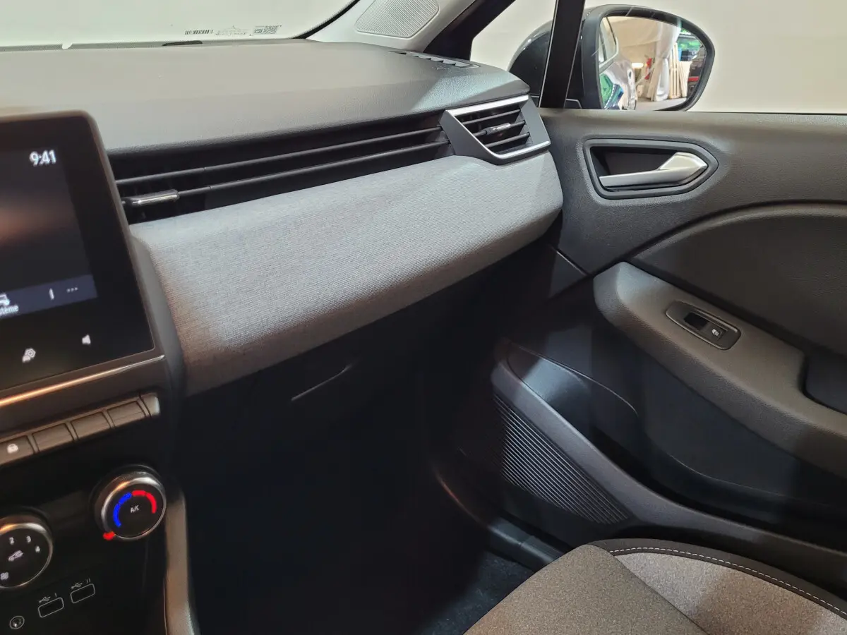 Intérieur côté passager de la Renault Clio Evolution Blue dCi 100 2025, tableau de bord gris clair et garnitures noires.