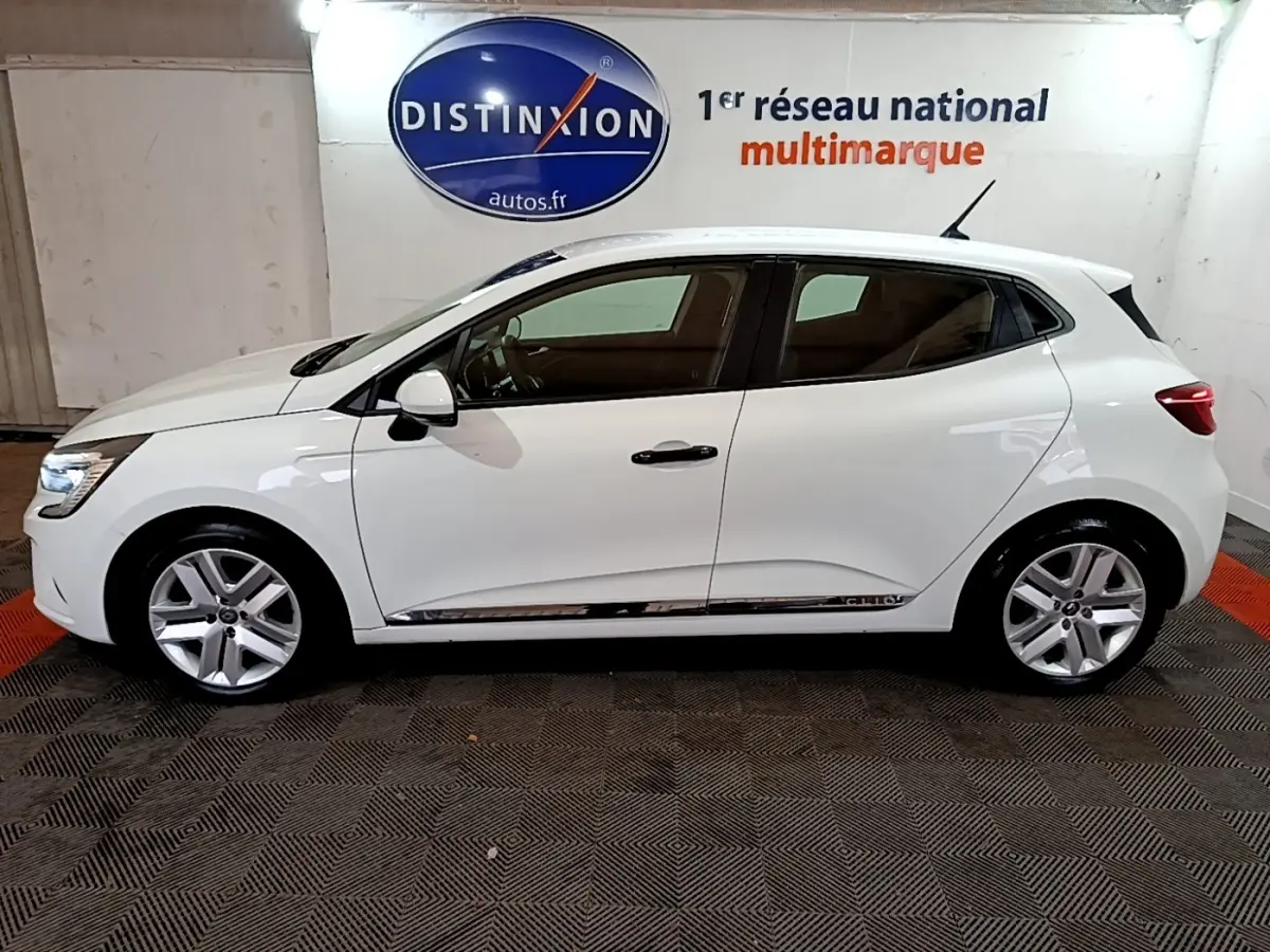Profil droit d'une Renault Clio Business blanche 2021, avec jantes alliage et rétroviseurs blancs assortis.