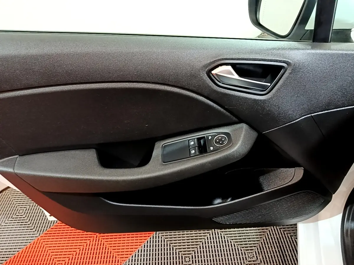 Vue intérieure sur la porte avant gauche noire de la Renault Clio Business blanche, avec commandes des vitres et rétroviseurs.
